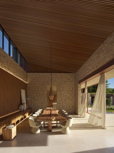 Contemporary dining room with wood ceiling and stone wall - IB house