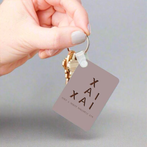XAI keychain held in hand - Xai-Xai hotel
